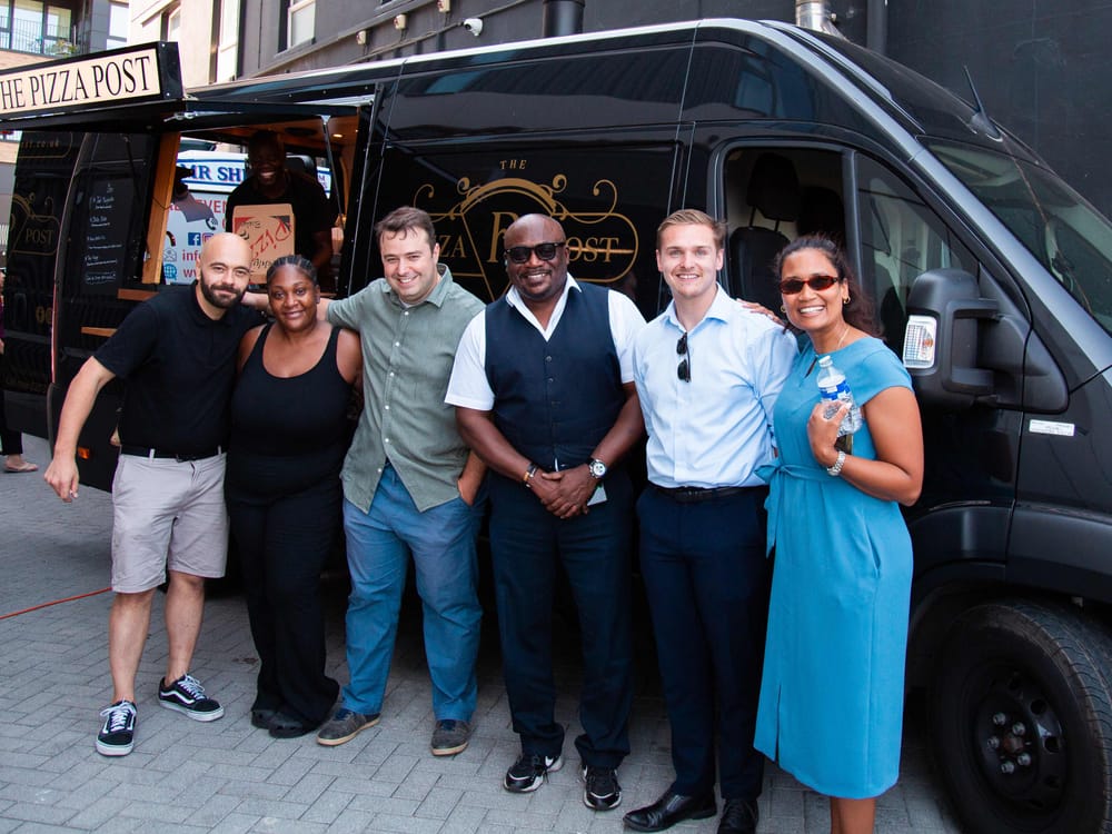 The Flint Housing team and delivery partners gathered in front of The Pizza Post wood-fired pizza van