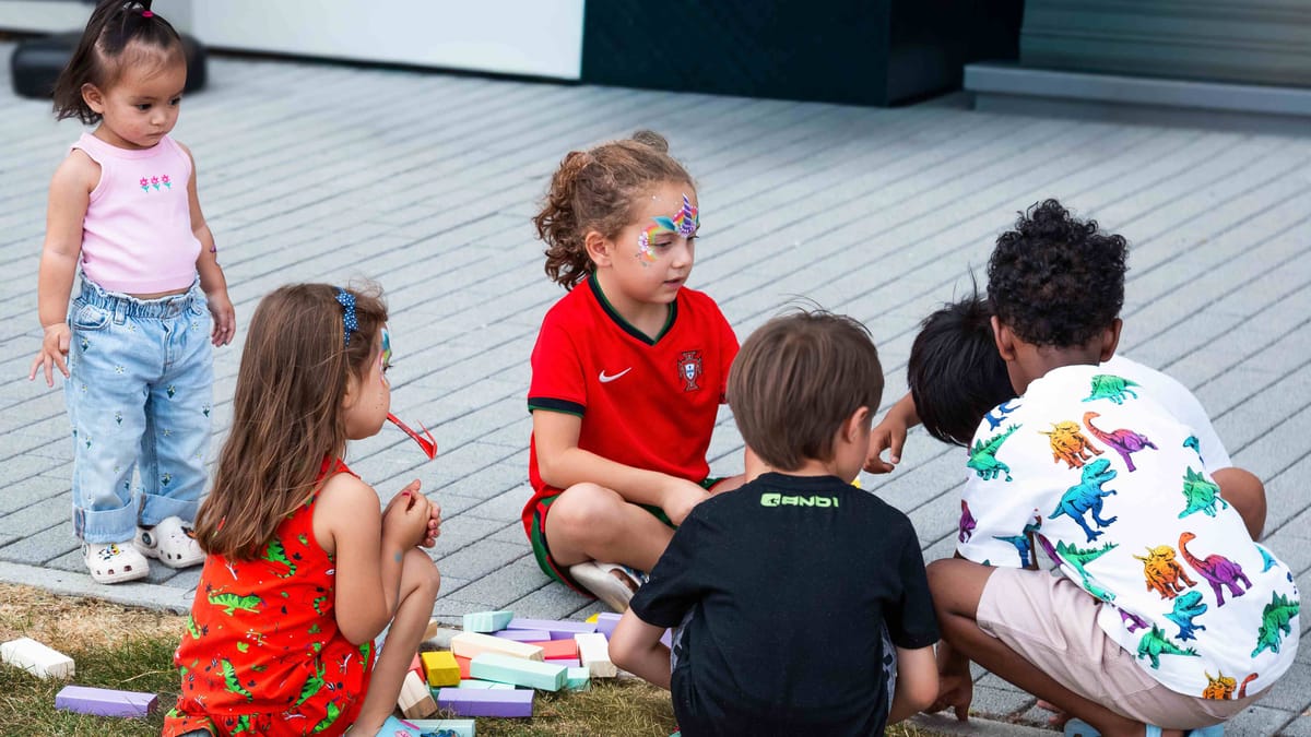 Children with face paint playing with building blocks together at the North Kensington Gate resident engagement day